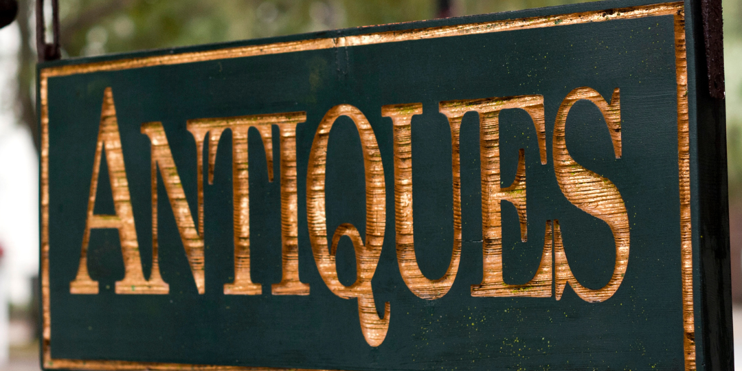 a hanging sign wih the word antiques and the title Denham Springs