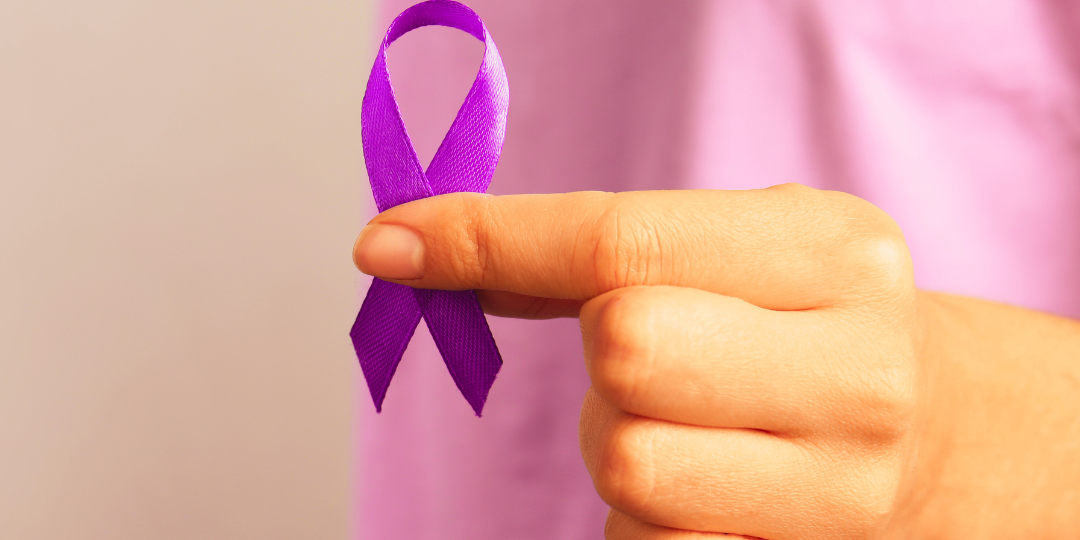 woman in a pink shirt holding a purple ribbon and a banner reading Crossroads Area Domestic Violence Resources